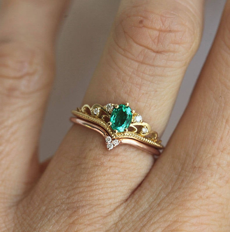 Elegantan ovalni smaragdni prsten sa smaragdnim klasterom markiznog reza i dijamantima. Bend u vintage stilu od 14k ili 18k zlata.