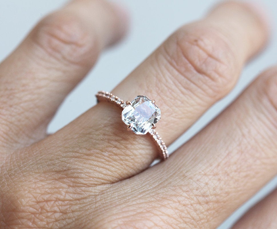 Radiant white sapphire ring with side diamonds