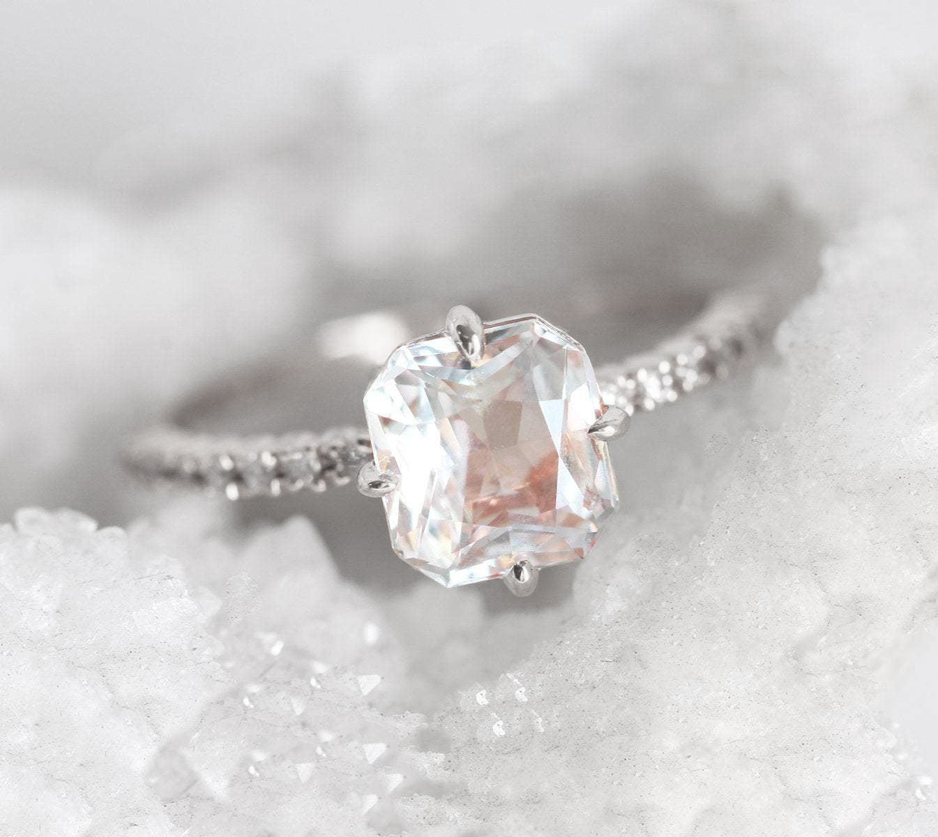 Radiant white sapphire ring with side diamonds